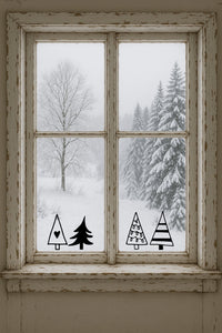 vier schwarze Vinyl-Fensteraufkleber in Tannen-Form auf Scheibe vor winterlicher Landschaft – minimalistische Weihnachtsdeko